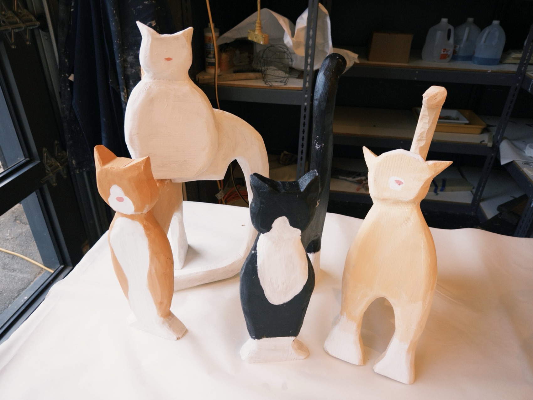 Four carved and painted wooden cats